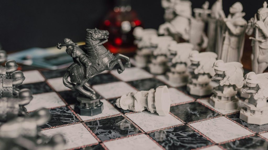 Close-up of a fantasy-themed medieval chess set with intricate details, highlighting a knight piece.